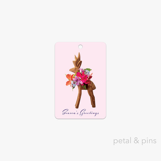 festive floral reindeer gift tag by petal & pins featuring a reindeer with a wreath of flowers on a pink background