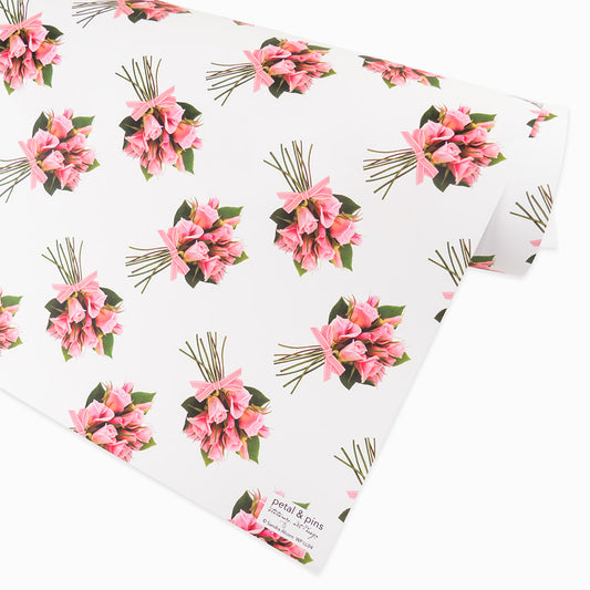 Rose posies wrapping paper by petal & pins. Floral patterned paper with pink flowers and green leaves on a white background.