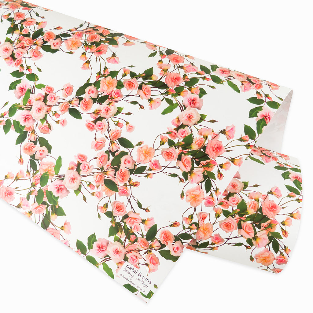 Rose lattice wrapping paper by petal & pins. Floral patterned paper with pink flowers and green leaves on a white background.
